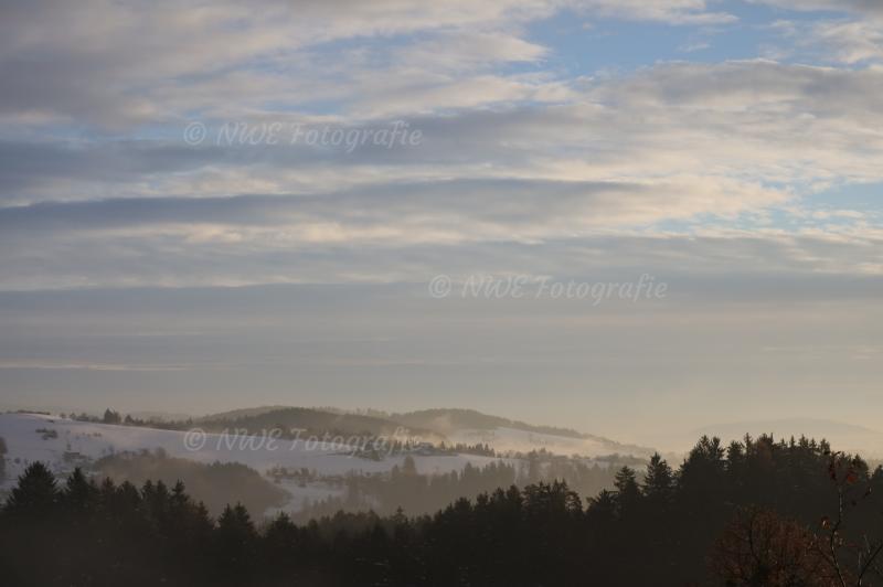 Hügellandschaft bei Sonnenaufgand im Nebel