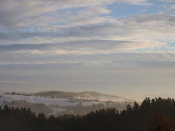 Hügellandschaft bei Sonnenaufgand im Nebel